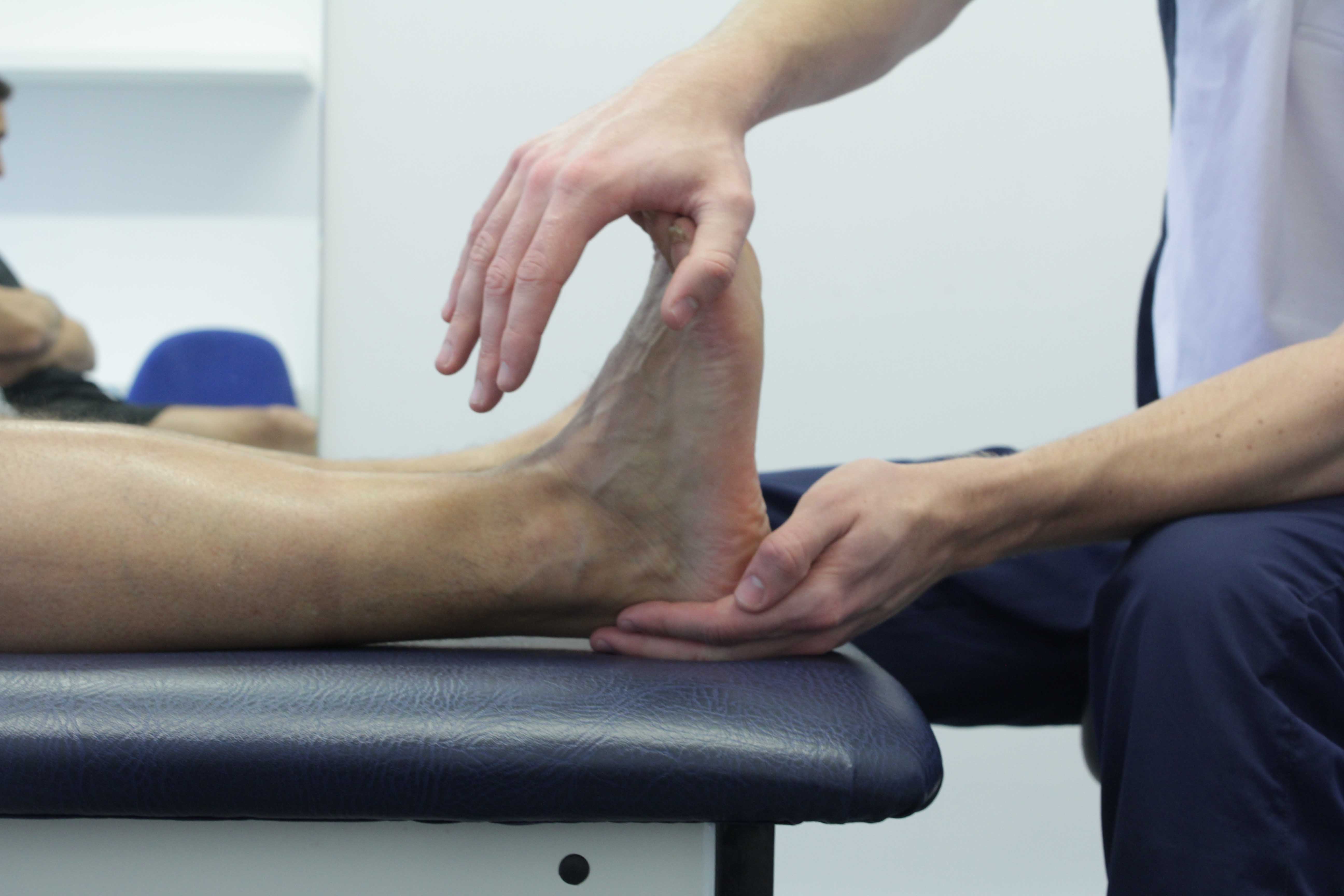 Our therapist relieving the pressure of retrocalcaneal burtitis through a deep stretch